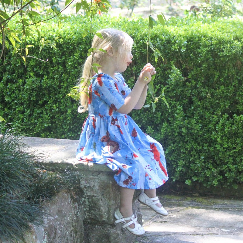 Little girl sitting on rock.