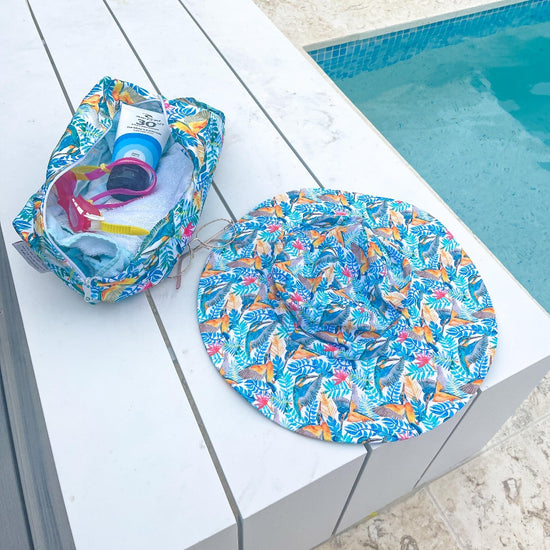 Hat and swim bag sitting next to pool on a table