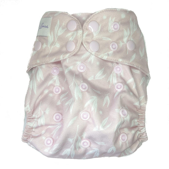 Pale pink cloth nappy with leaves on the fabric. 