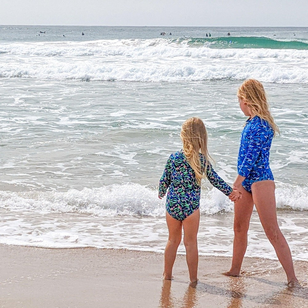 Two young girls holding hands at the beach