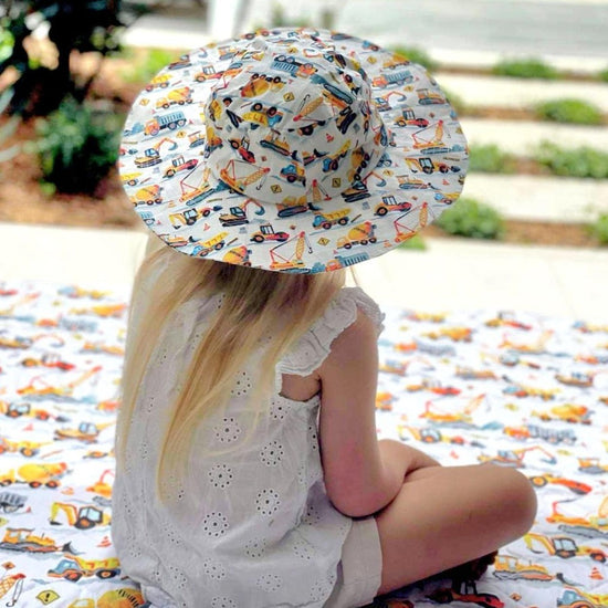 Load image into Gallery viewer, Little girl sitting on a play mat wearing a matching hat. 
