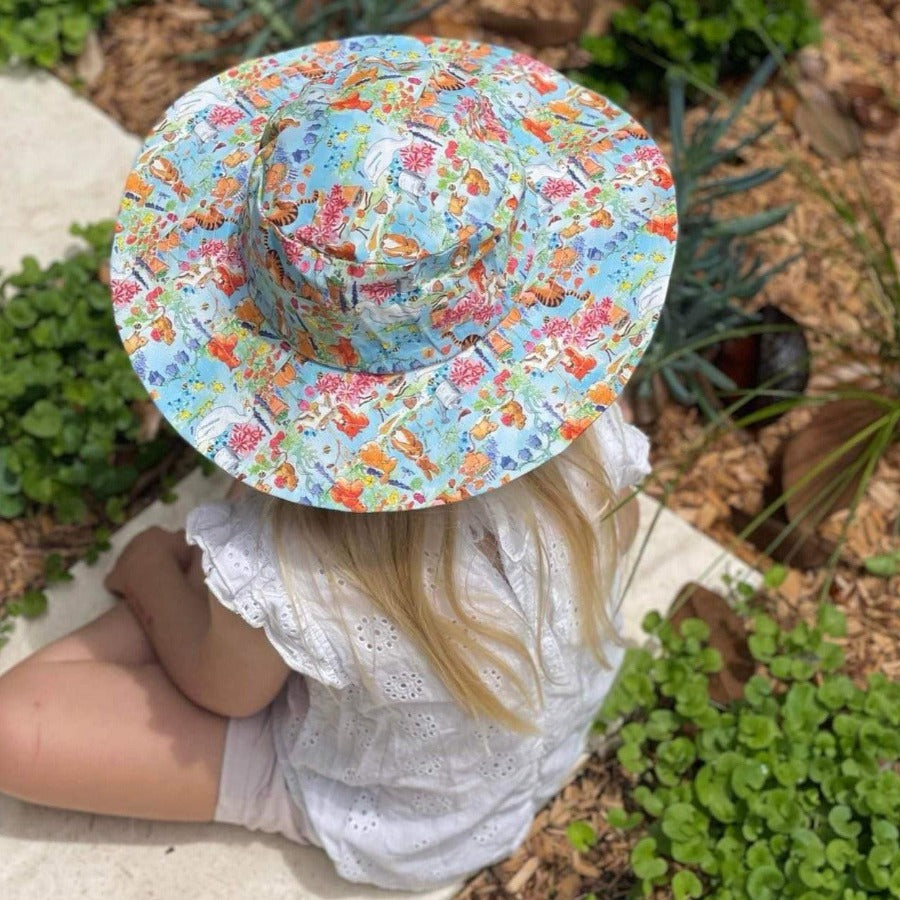 Little girl wearing a wide brim hat. 