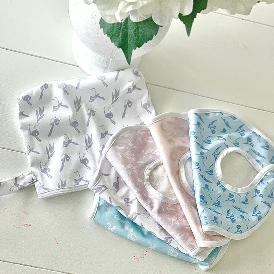 Baby Bibs on table with different pastel coloured prints