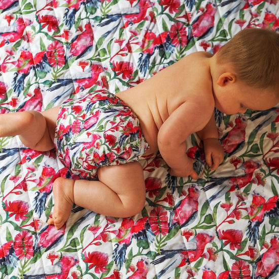 Baby wearing cloth nappy on matching play mat