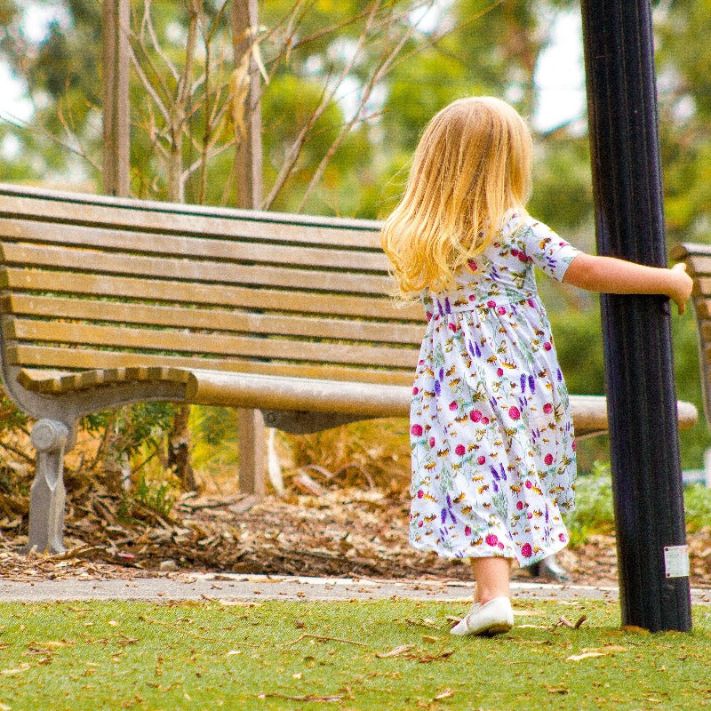 Load image into Gallery viewer, Little girlswinging on a pole in a park. 
