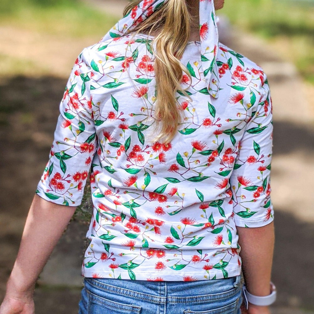 
                  
                    Close up of a girl wearing a long sleeved t-shirt with e gumnut print
                  
                