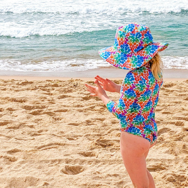 Child wearing wide brim hat at beach