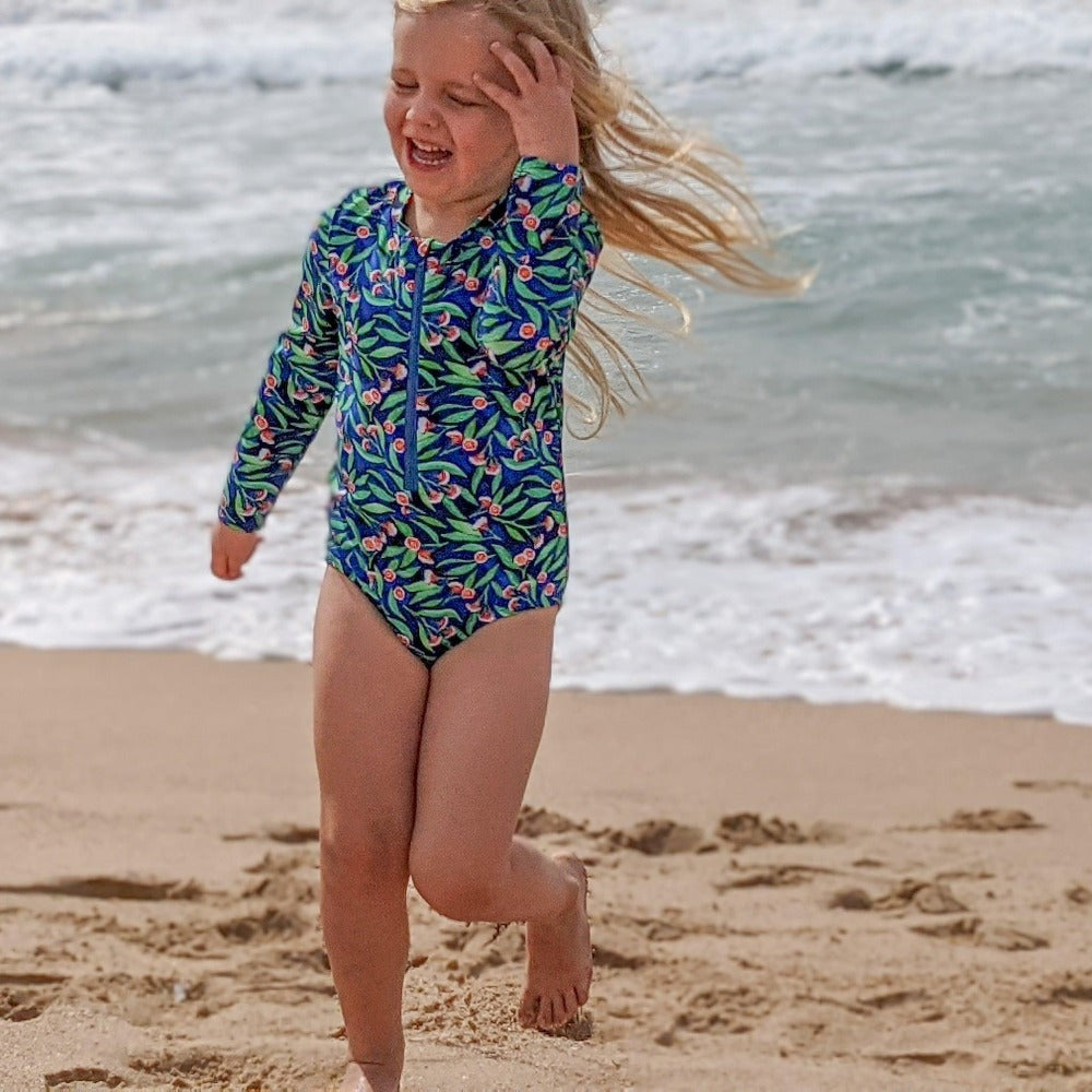 Child running on beach in swimsuit